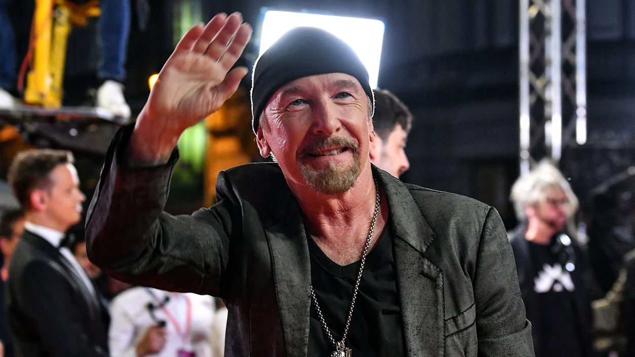 Guitarist of "U2", David Howell Evans aka The Edge gestures as he arrives at the red carpet area, in front of Bosnian National Theater before the premiere of the motion picture "Kiss The Future", during the grand opening ceremony of the 29th edition of the Sarajevo Film Festival in Sarajevo, on August 11, 2023. The film "Kiss The Future" follows the story of the Irish rockers before and during organization of their concert in war torn Sarajevo in 1997. (Photo by ELVIS BARUKCIC / AFP) (Photo by ELVIS BARUKCIC/AFP via Getty Images)